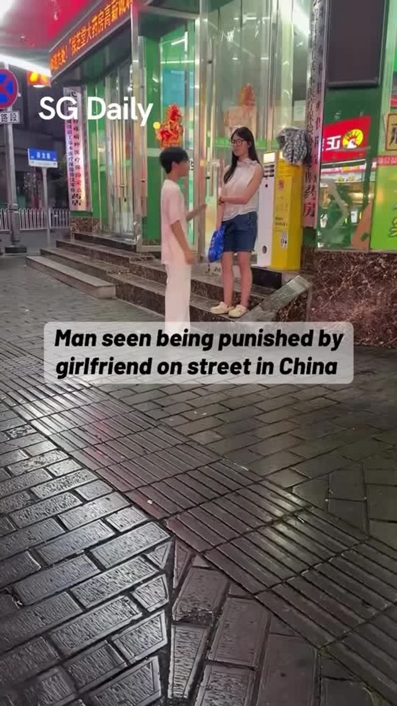 Man seen kneeling on street in China as woman stands nearby