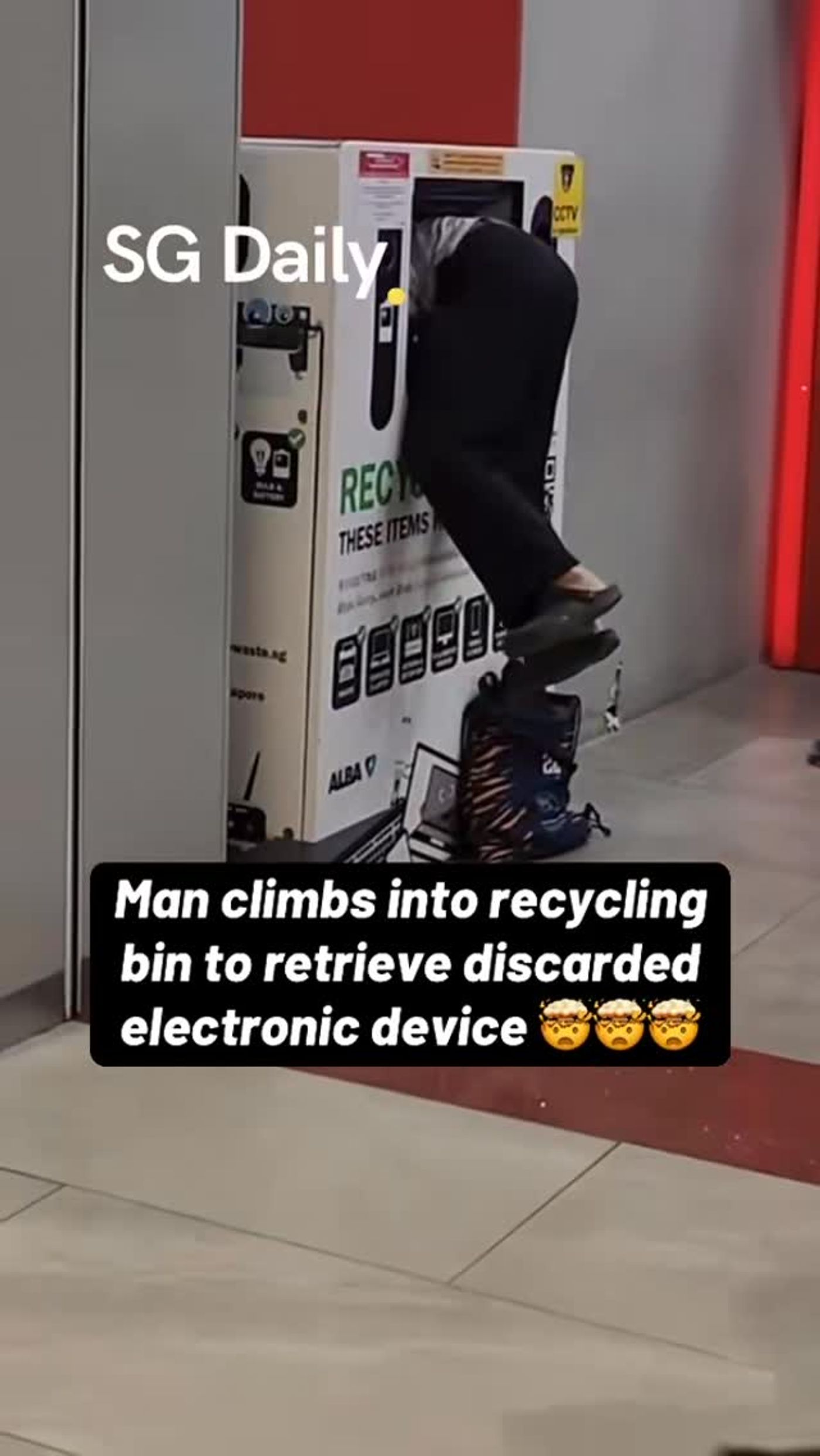Man climbs into e-waste bin to retrieve a discarded device