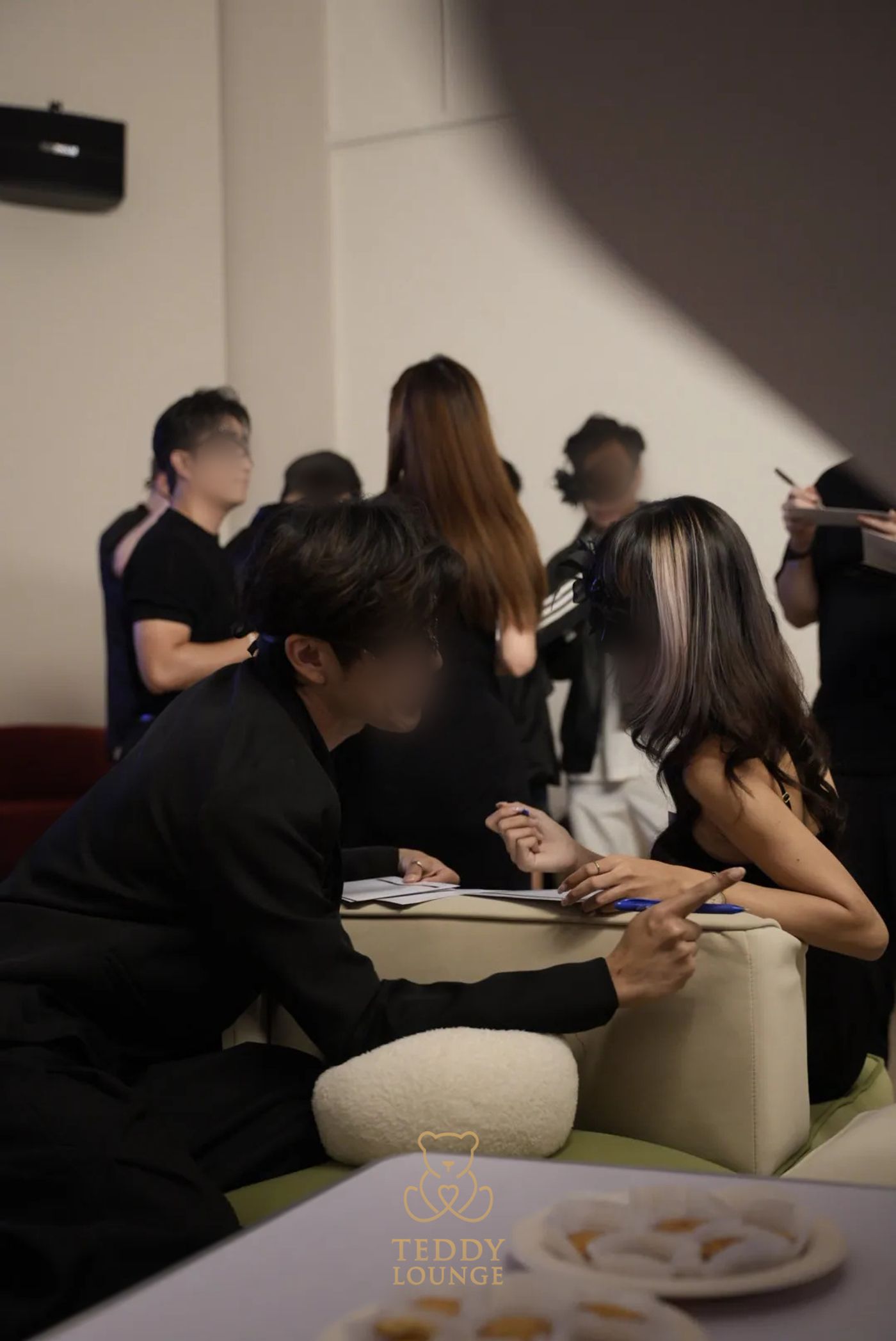 Two masked guests sit across from each other during a Teddy Lounge activity.