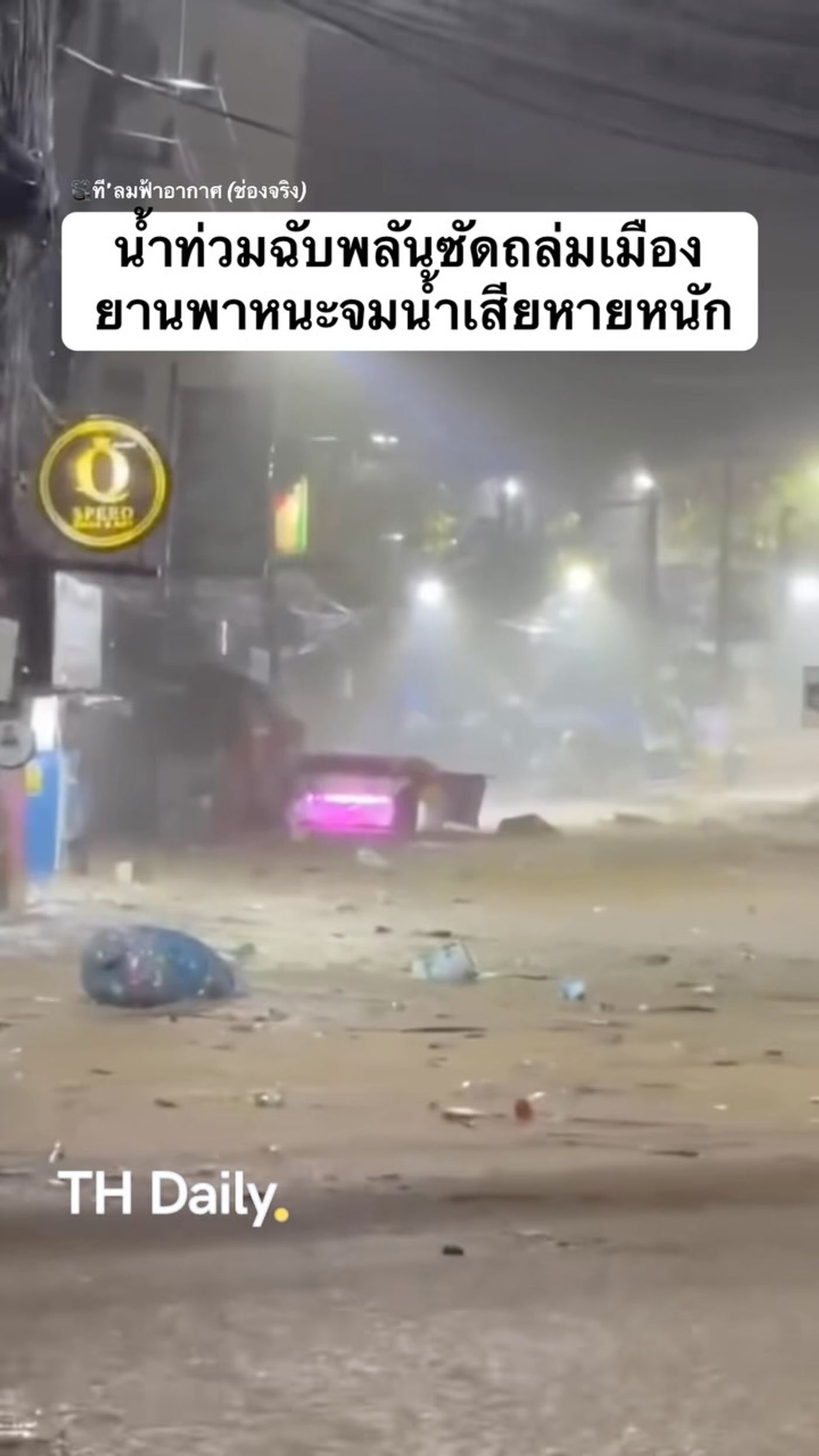 Floodwater surrounds vehicles on a street at night