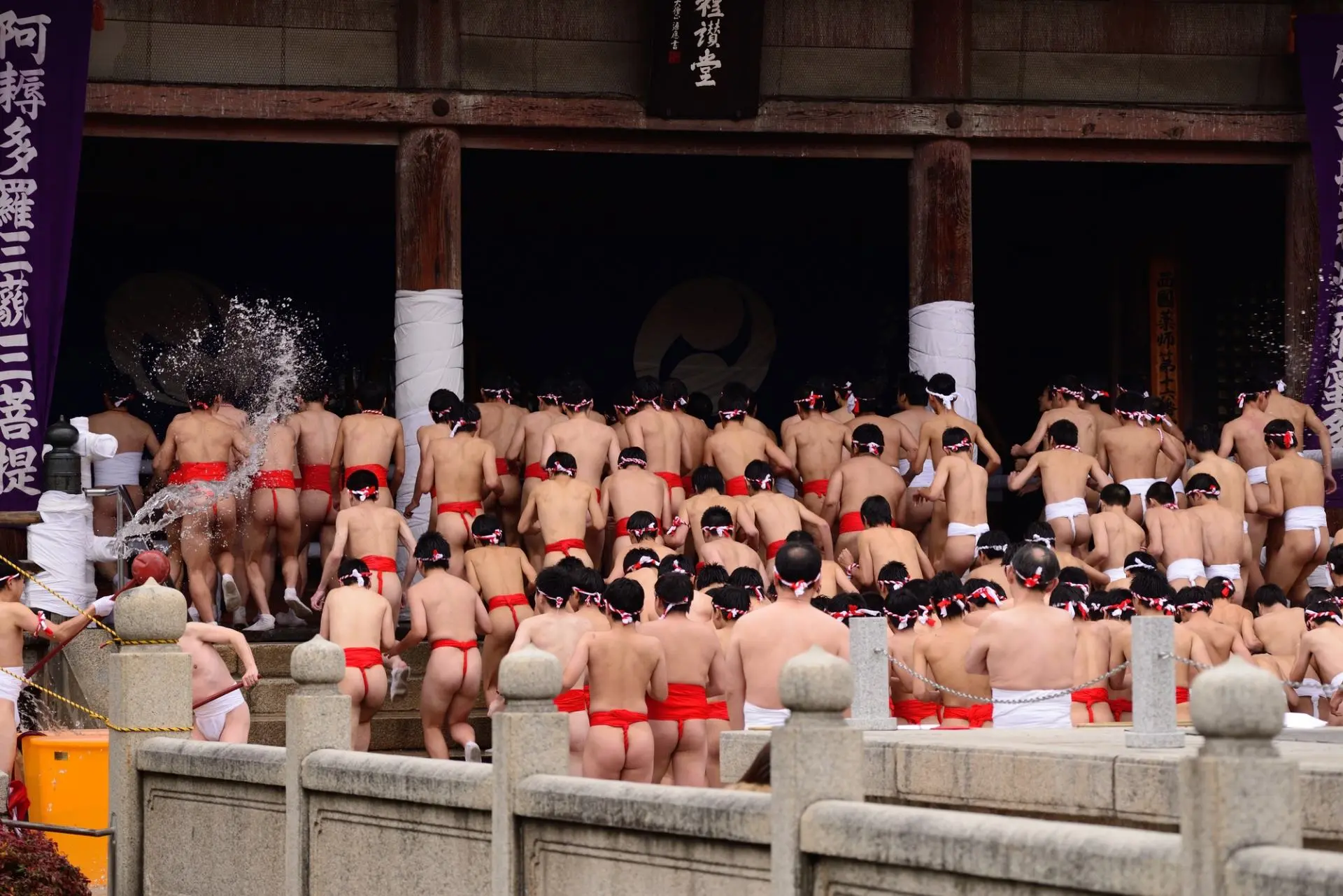 Winter street food market in Osaka, Japan, showcasing traditional dishes like steaming hot pots, takoyaki, and oden. Vendors and customers are dressed in warm winter clothing, with vibrant lanterns and wooden signs creating a cozy, authentic Japanese atmosphere.