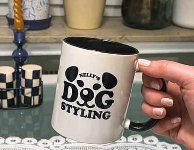 Black wordmark forming a dog's face on white, floppy ears, eyes and snout built into the chunky letters "DOG"