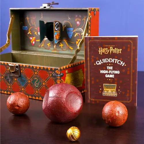 Un set de juego "Harry Potter Quidditch" con un baúl decorativo, tres pelotas parecidas a las quaffles y una snitch dorada.