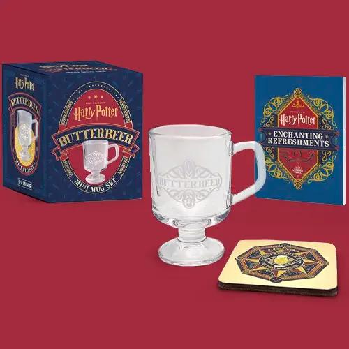 Un set de mini taza de Cerveza de Mantequilla de Harry Potter, que incluye una taza de cristal, un posavasos y un libro pequeño.