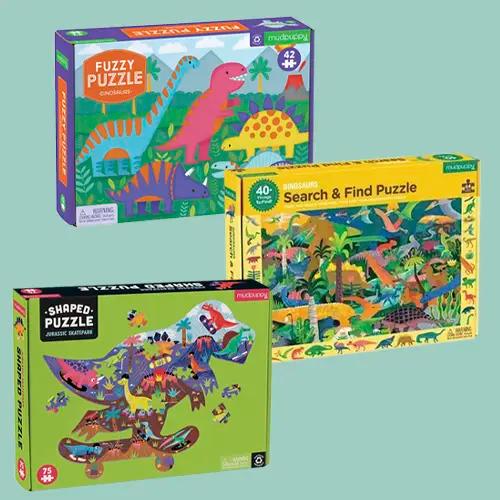 Tres cajas de rompecabezas de dinosaurios Mudpuppy, incluyendo "Fuzzy Puzzle", "Search & Find Puzzle" y "Shaped Puzzle"