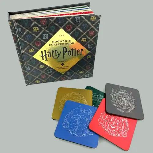 Un "Libro de Posavasos de Hogwarts de Harry Potter" con varios posavasos coloridos que muestran los escudos de las casas de Hogwarts.