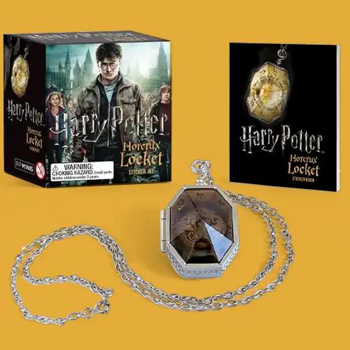 Un kit de pegatinas del guardapelo Horrocrux de Harry Potter, que incluye una réplica del guardapelo en una cadena y un libro de pegatinas.