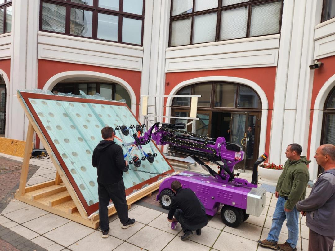 Quattrolifts vacuum lifter handling a large glass panel in an ornate building courtyard during a glass install
