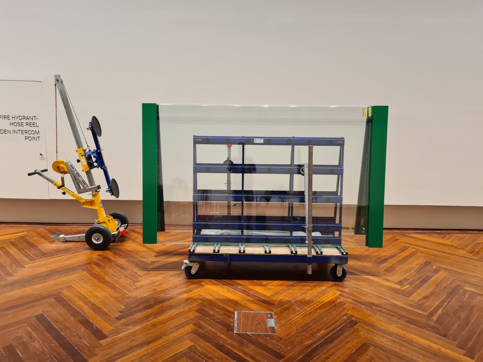 Quattrolifts vacuum glass lifter beside a large framed glass case in a museum gallery with timber floor