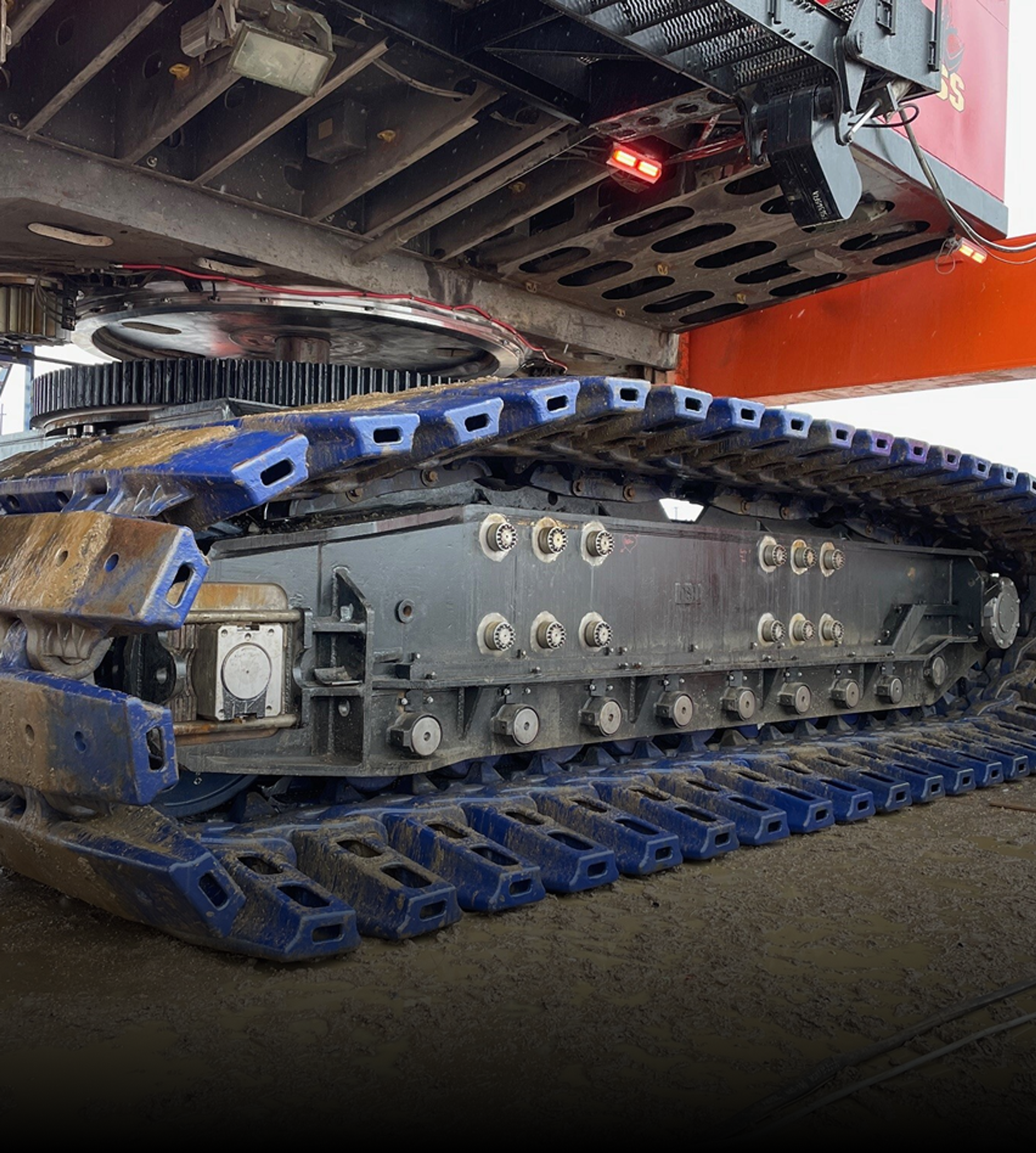 Close-up view of heavy-duty crawler track system and undercarriage of a large mining shovel.