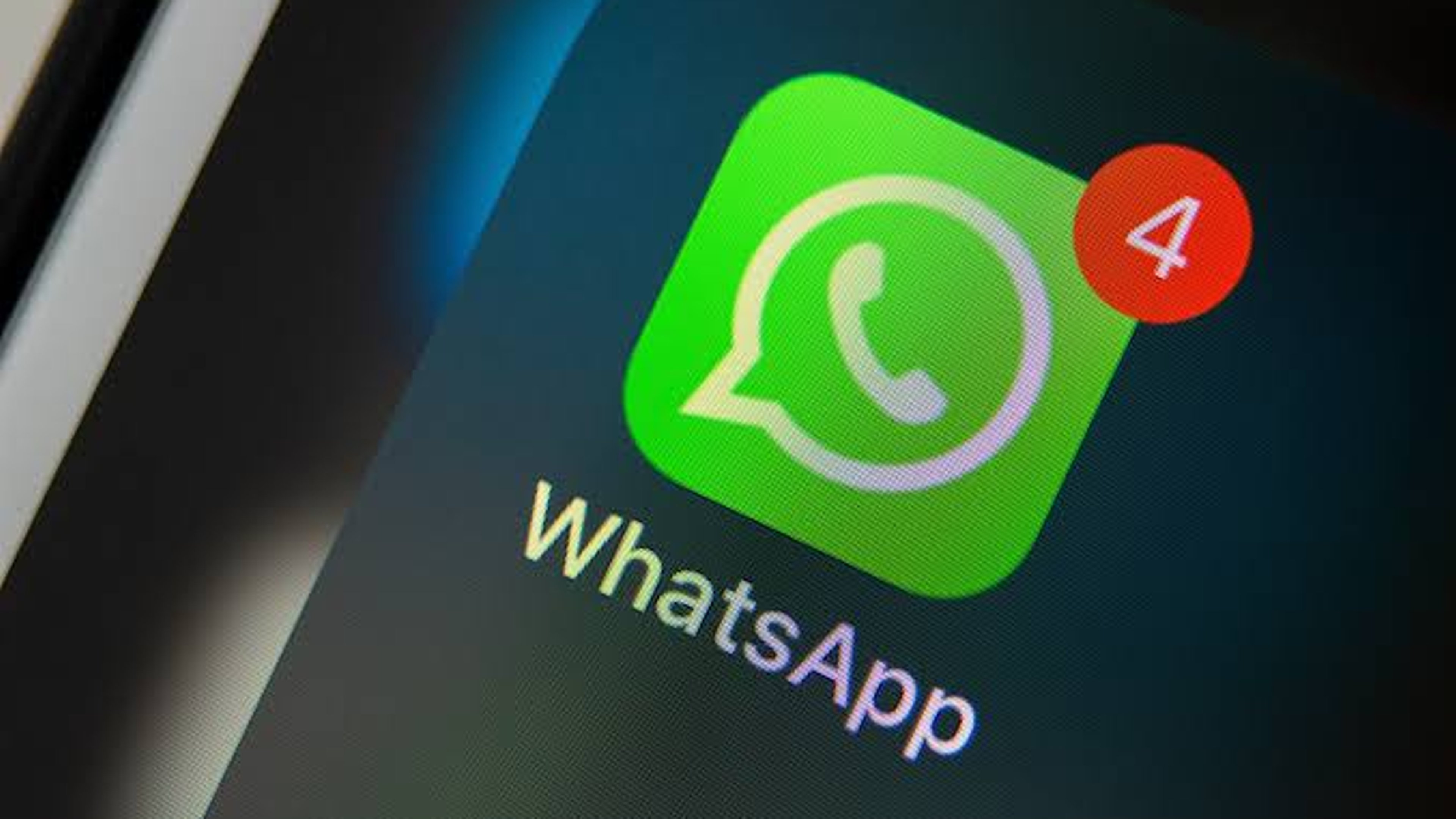 A WhatsApp logo sign showing a message notification: The platform is announcing radical changes affections iPhones