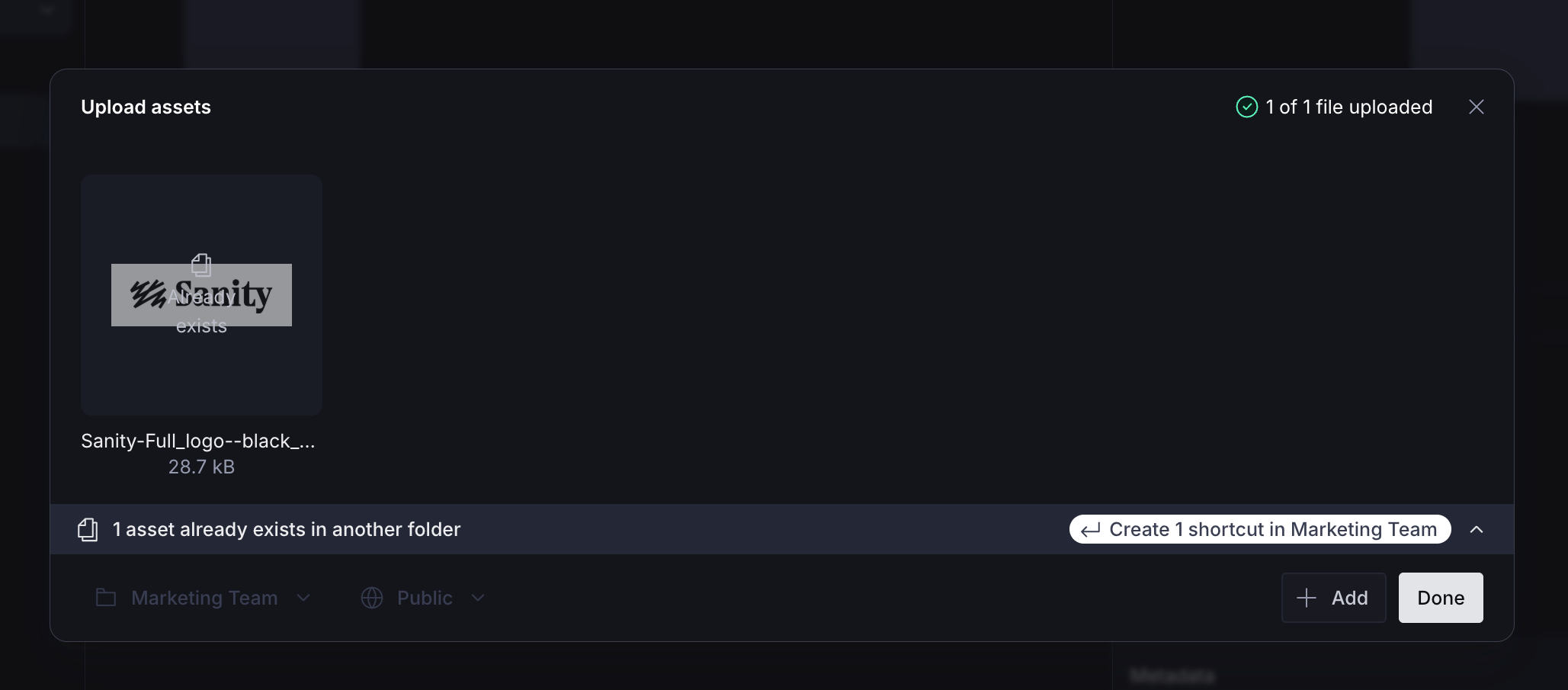 An "Upload assets" modal in a dark interface, showing a Sanity logo upload with "1 of 1 file uploaded" and an option to create a shortcut in "Marketing Team" for an existing asset.