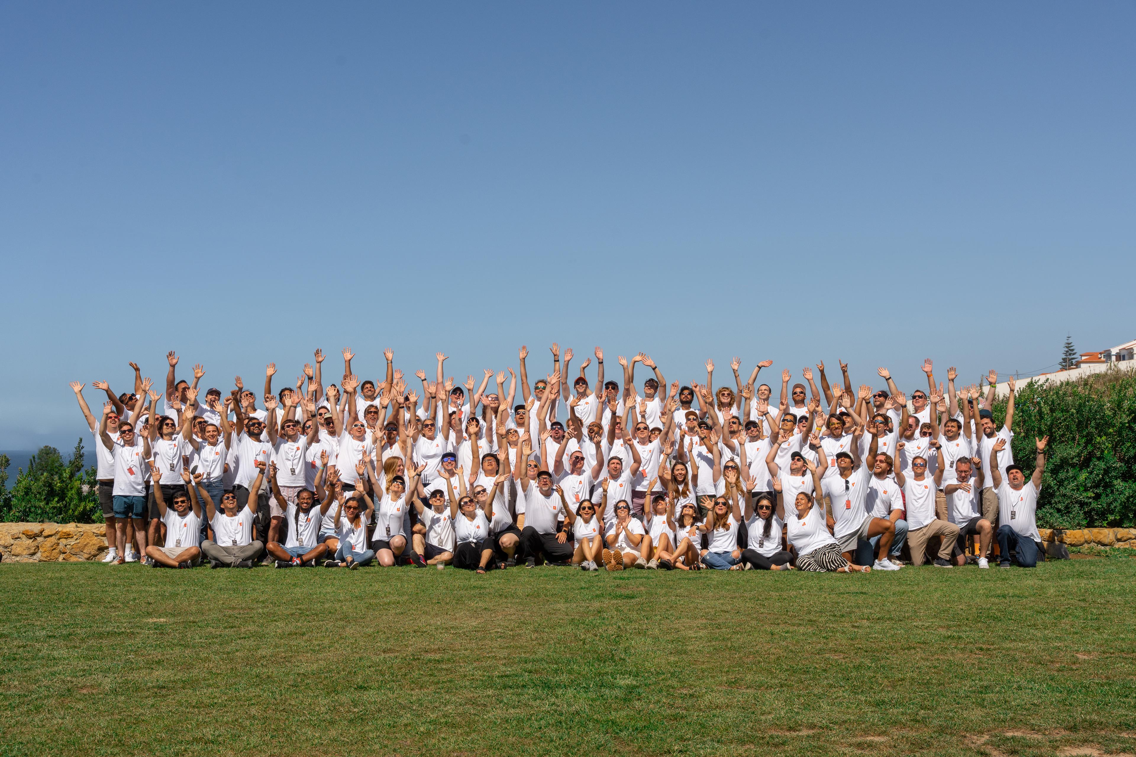 Large group of Sanity employees with hands up