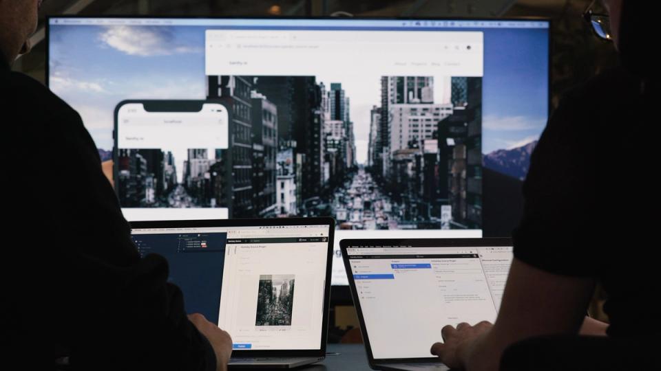 Two persons on laptops editing a website