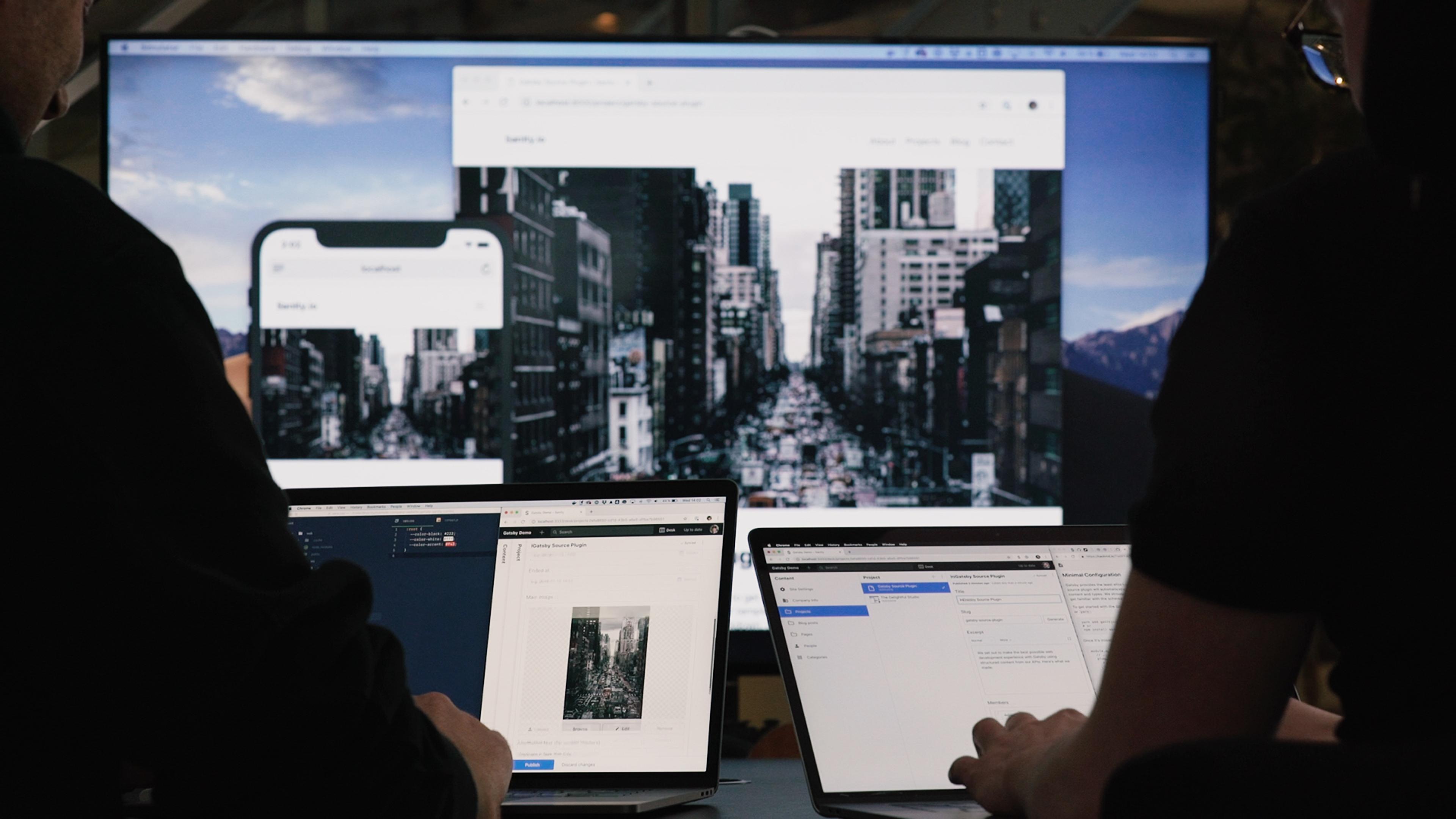 Two persons on laptops editing a website
