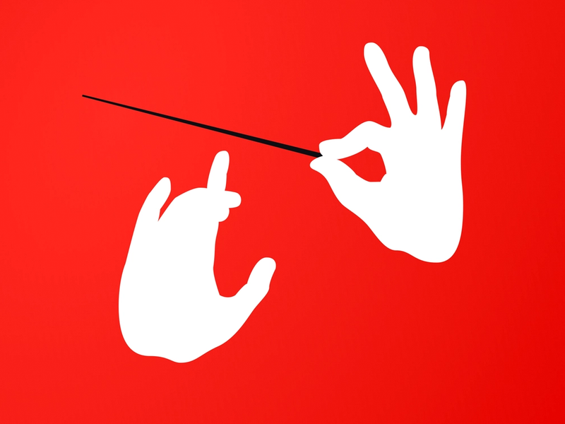 A pair of silhouette hands holding a conductors baton appearing to be conducting music.