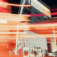 Night cityscape with buildings, illuminated billboards, and red motion-blurred light trails.