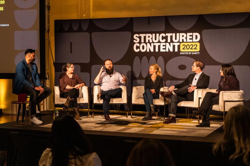 A group of people on stage discussing structured content
