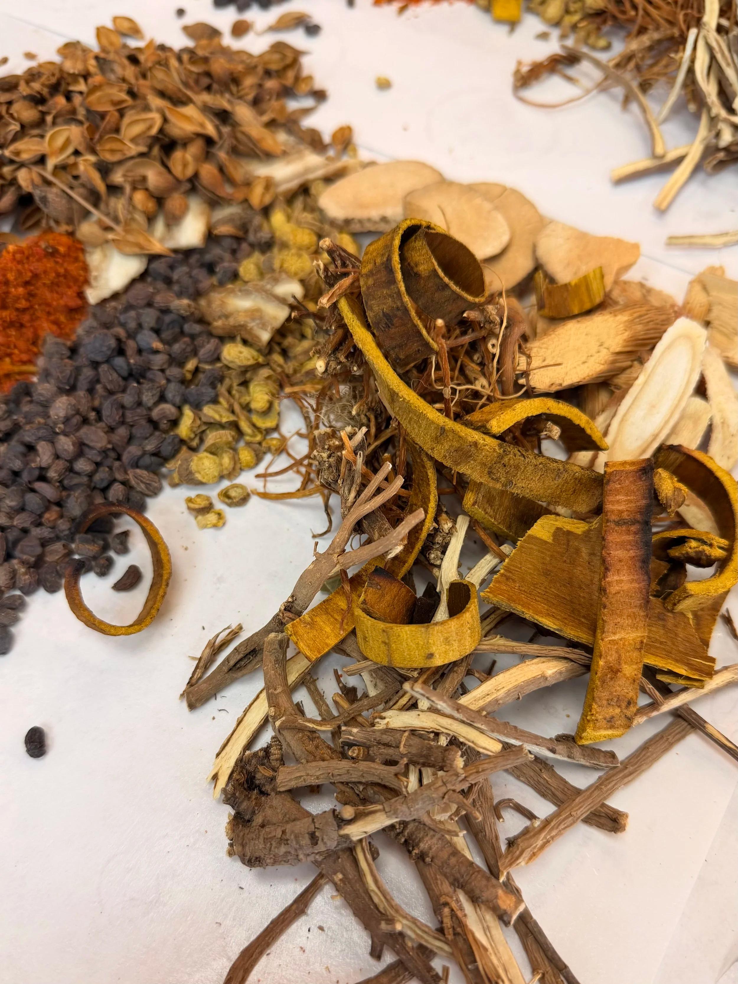 Dried herbs arranged on paper for a modified Long Dan Xie Gan Tang formula.
