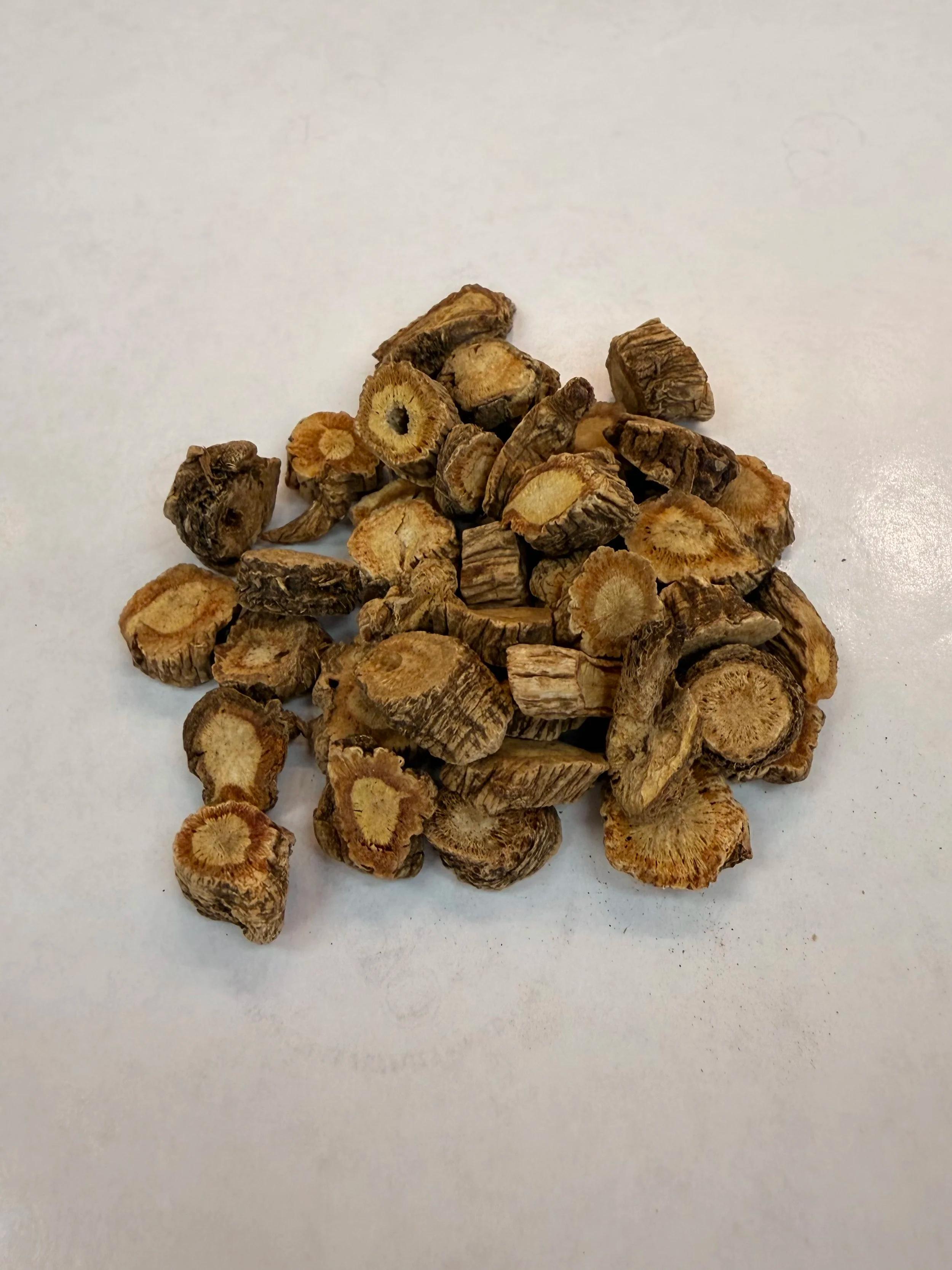 Dried slices of Fang Feng root on a light surface.
