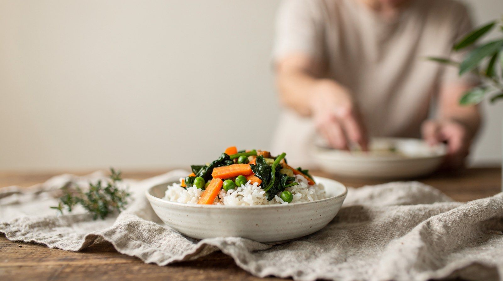 Una ciotola di riso con verdure cotte su un telo di lino.