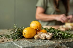 Agrumi, zenzero ed erbe fresche sul piano di una cucina.