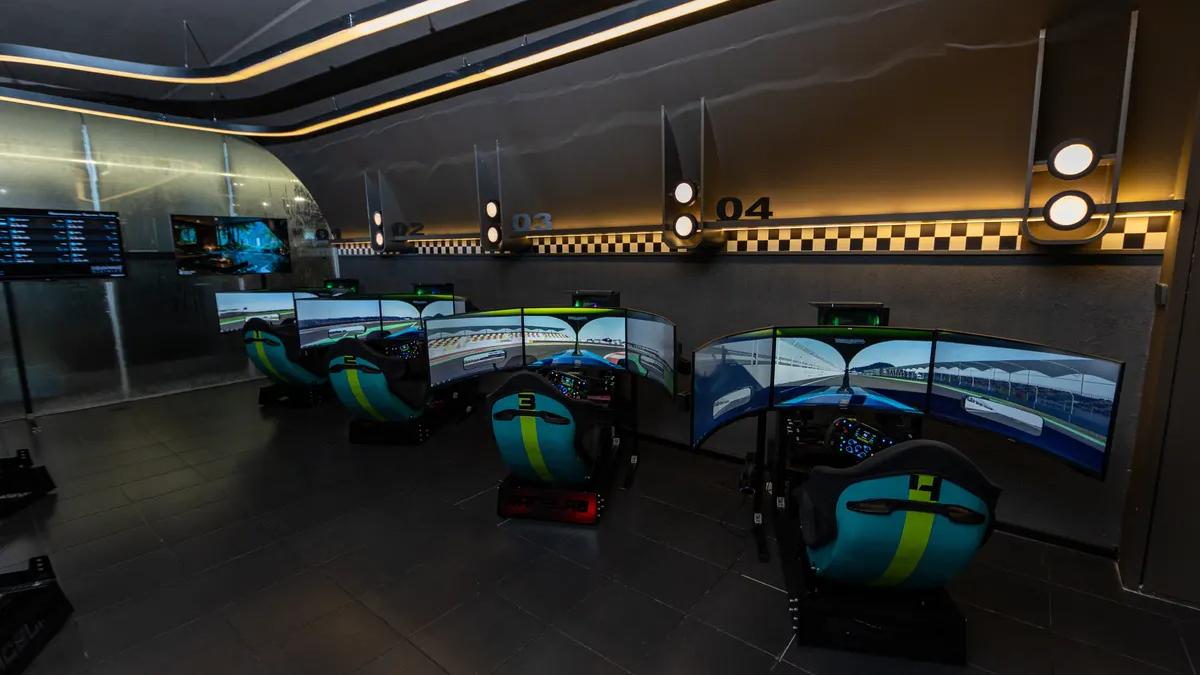 Deretan bay simulator dengan tiga layar melengkung di Race.inc
