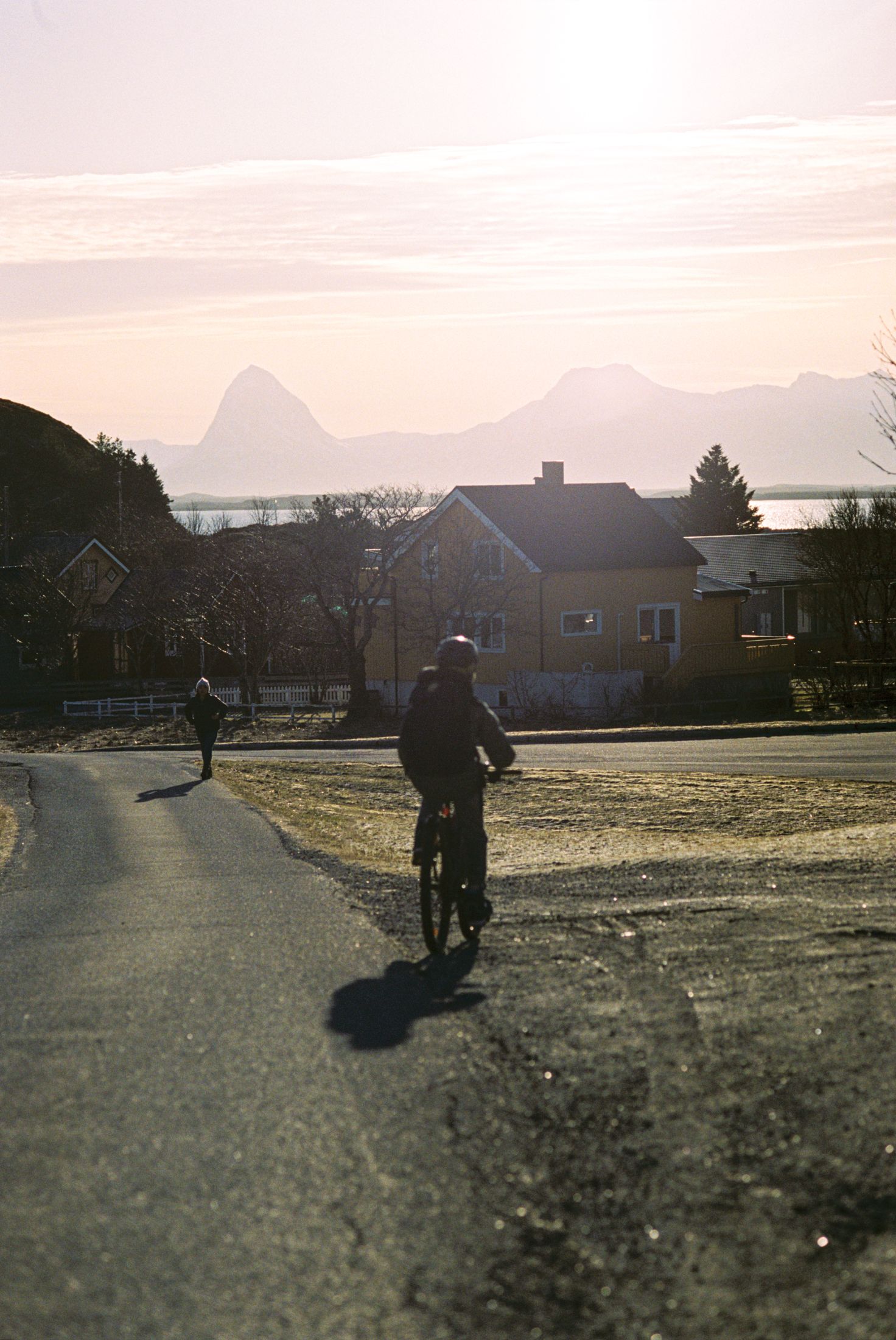Image of a person biking with Lovund in the background.