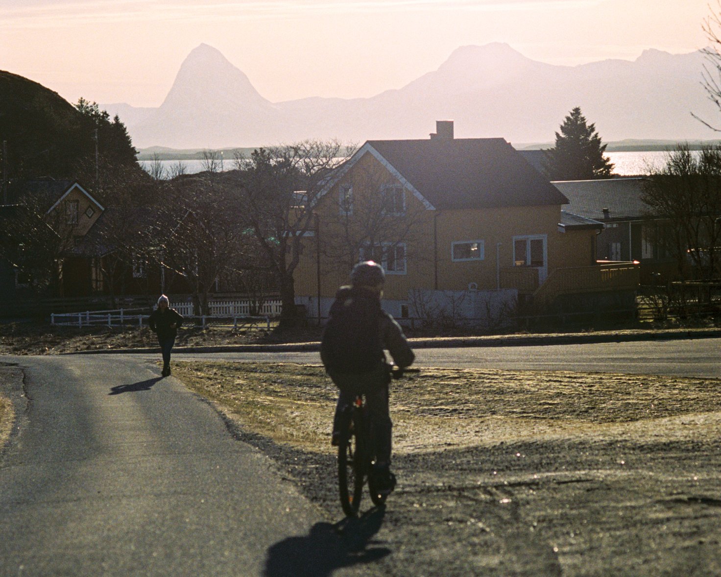 Image of a person biking with Lovund in the background.
