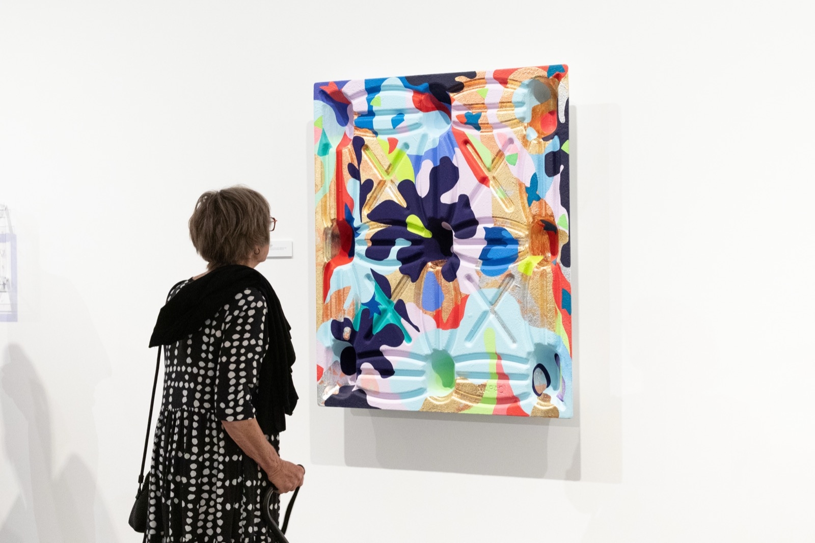 A visitor looking at a painting in the gallery
