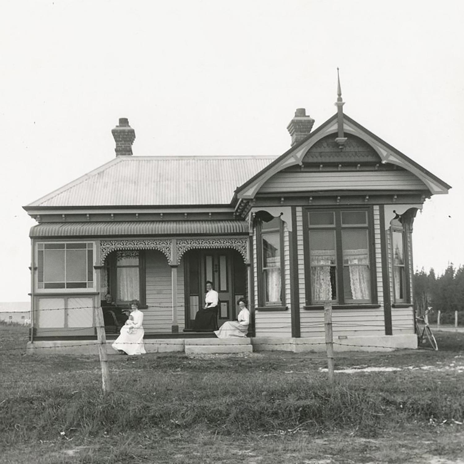 Historic photograph of a family sitting on the veranda of a rural villa in the Ashburton District.
