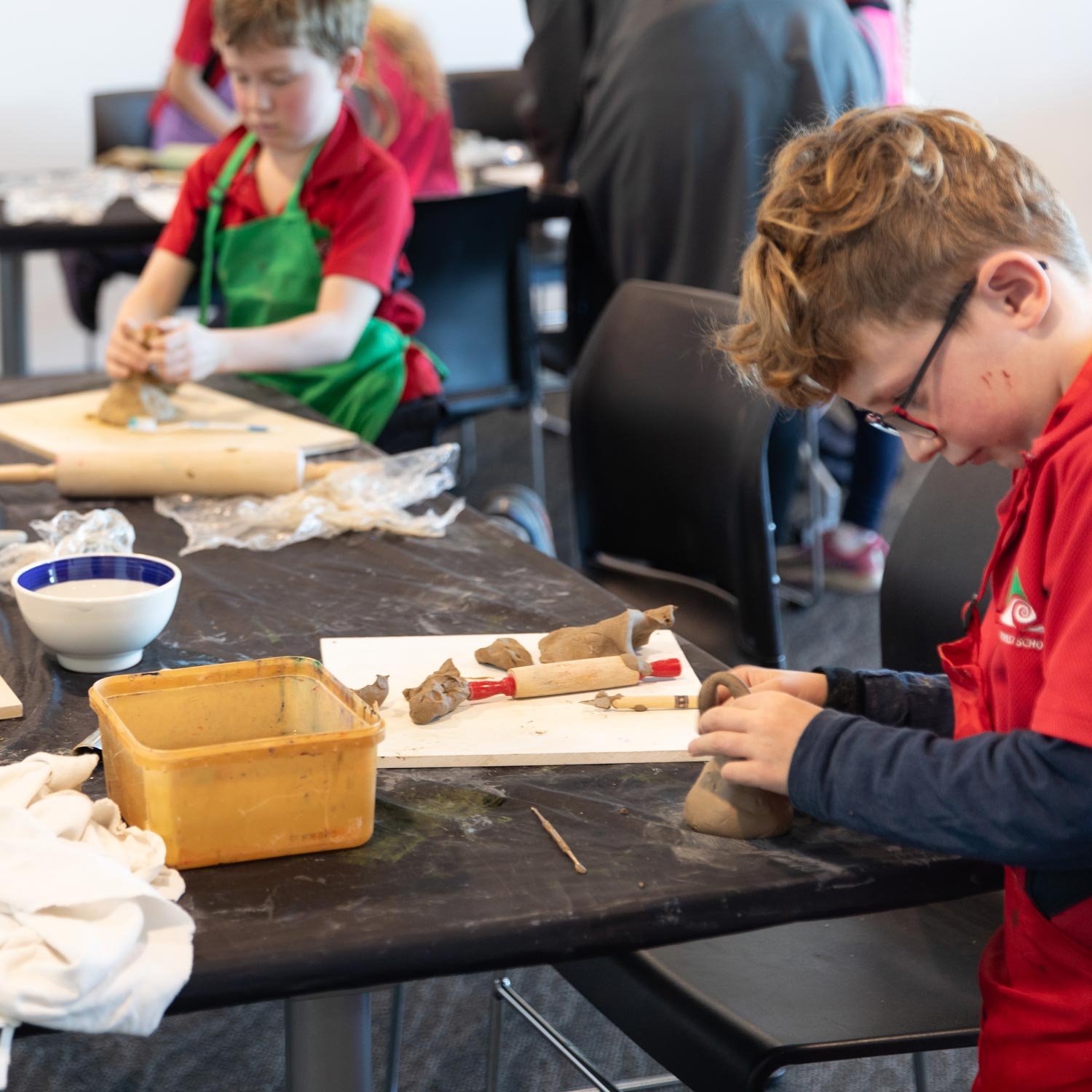Students practise clay pottery.