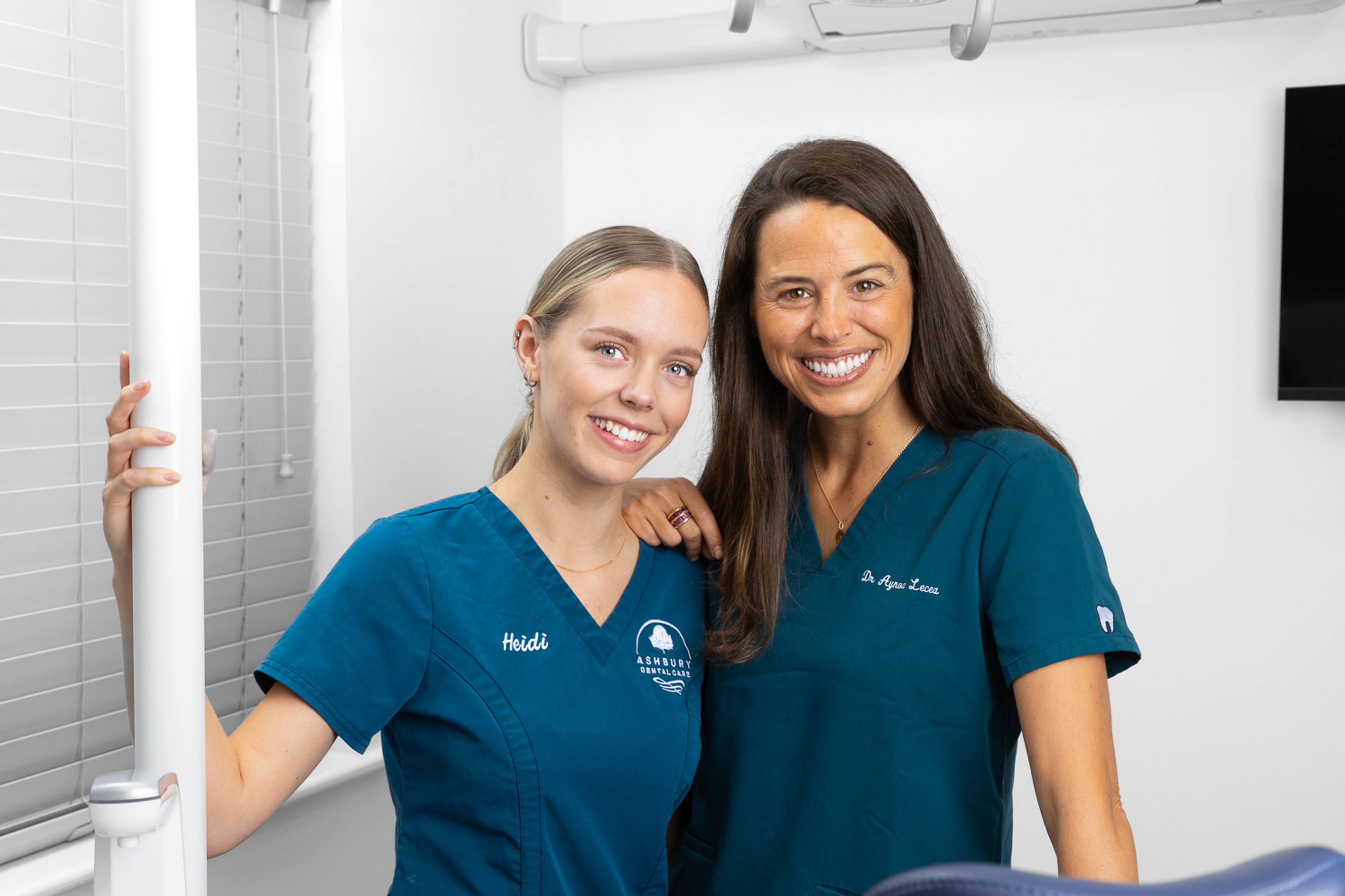 Two friendly dentists smiling in a clean, welcoming, treatment room