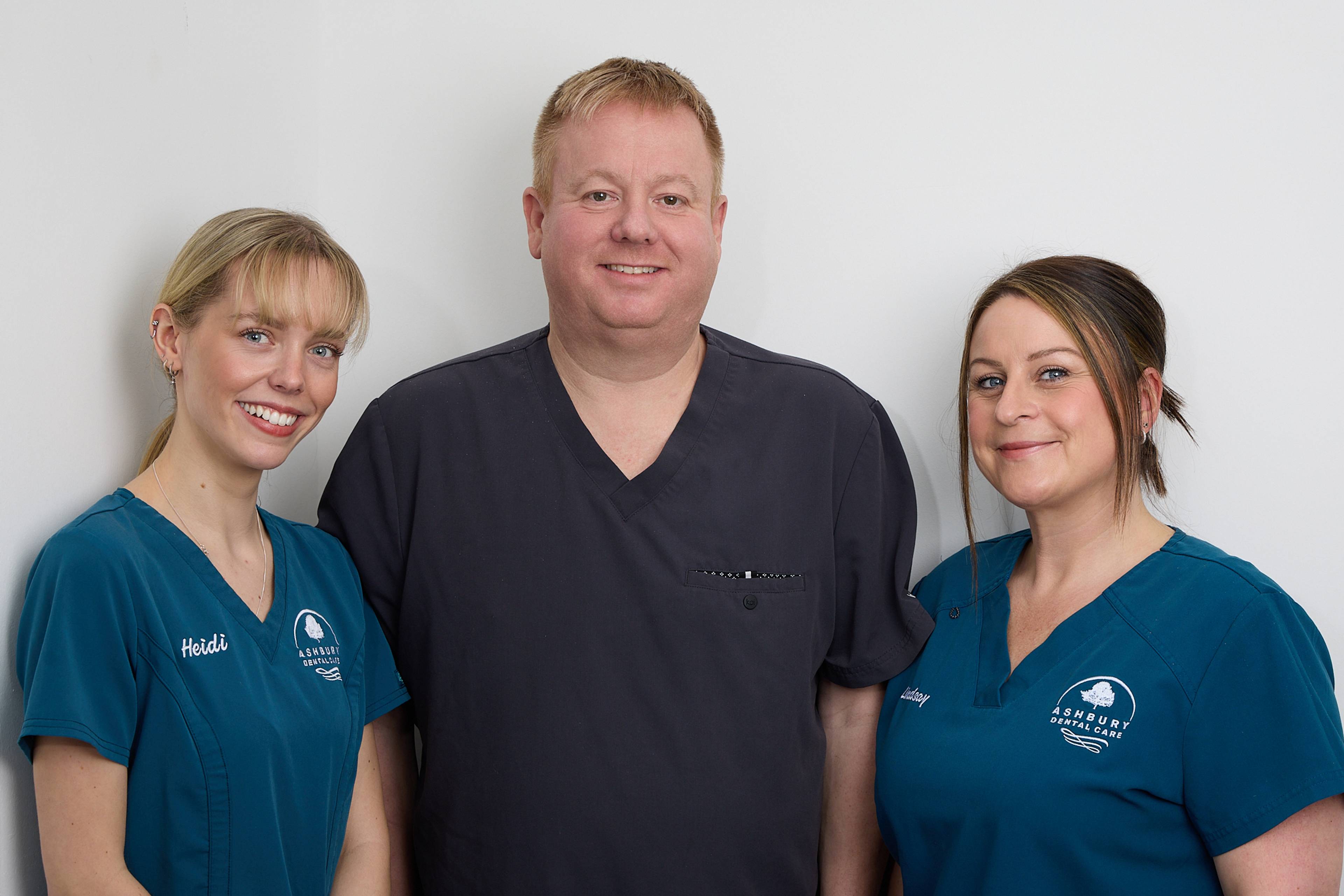 Dentist and two nurses stood smiling at Ashbury Dental Care