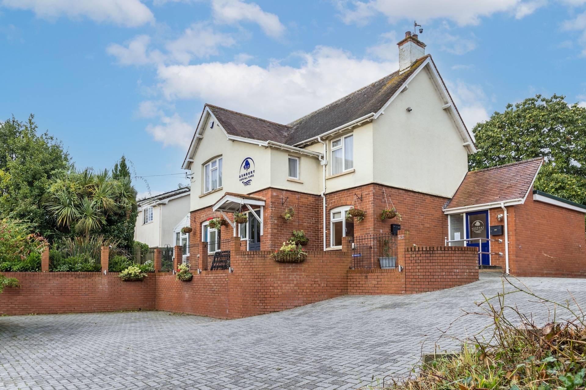 Ashbury Dental Care seen from the outside - a brick building in a leafy environment