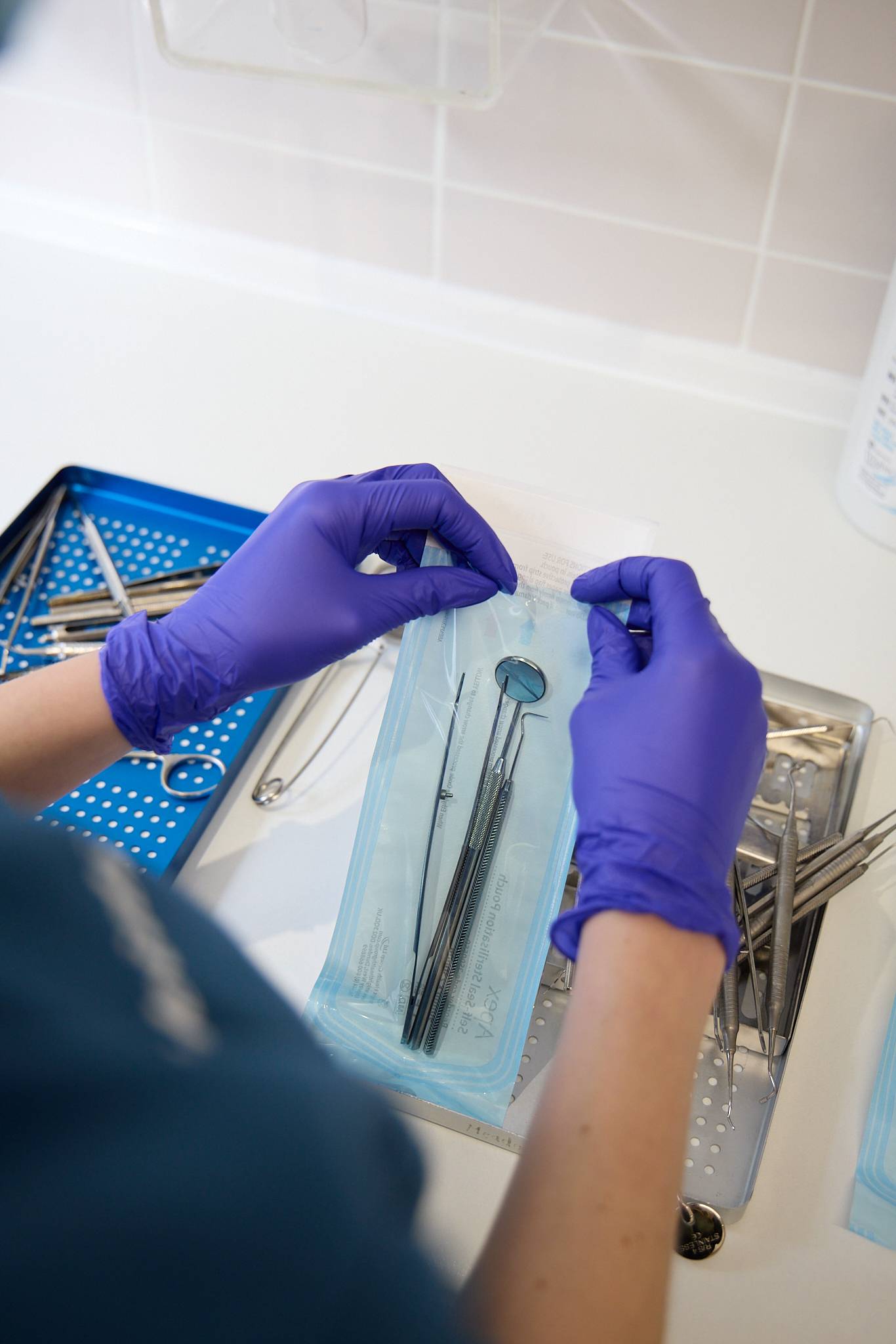 A dentist hands opening sterile instruments for treatment