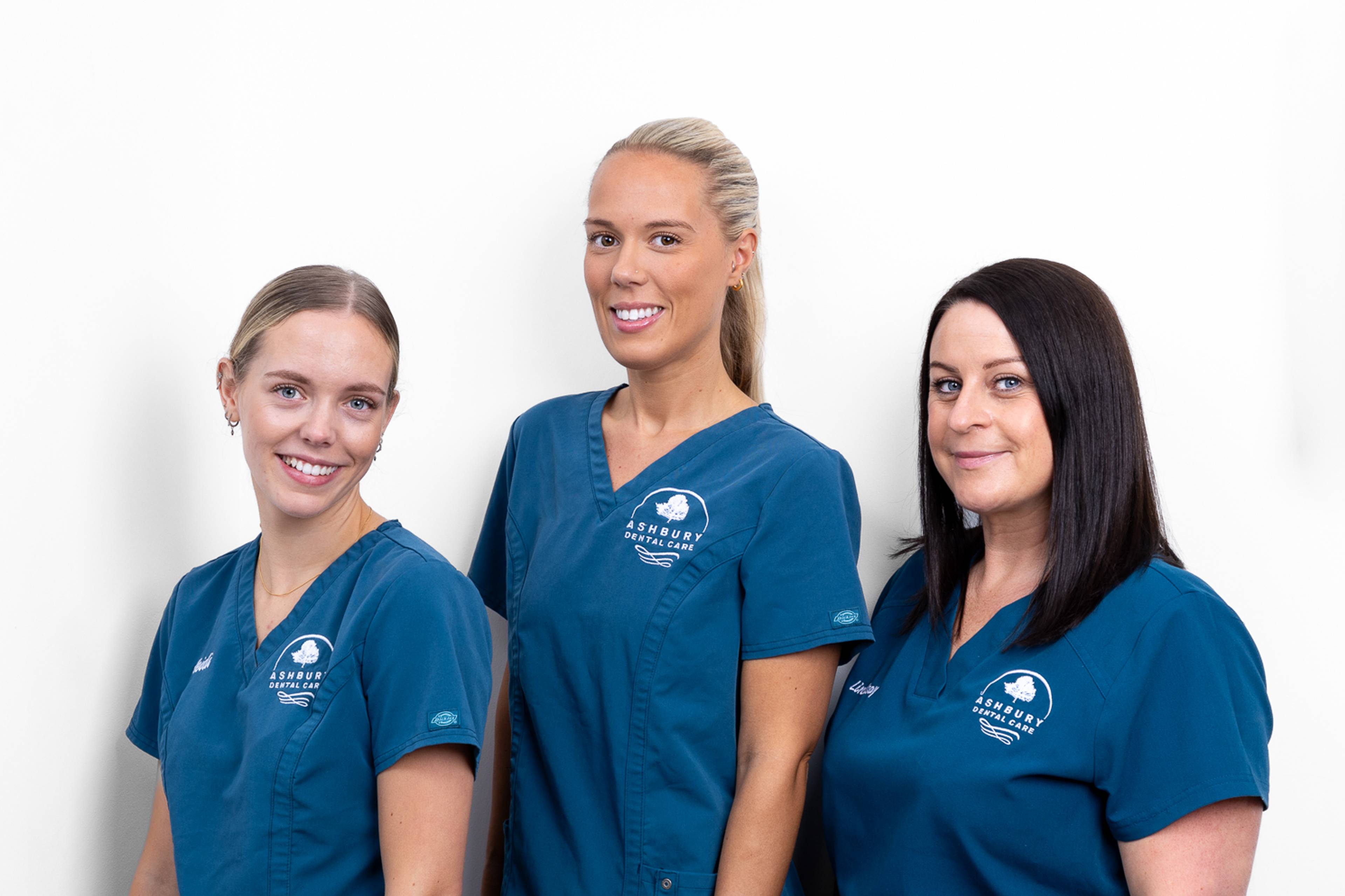 three of our Dental Nurses smiling in blue uniform