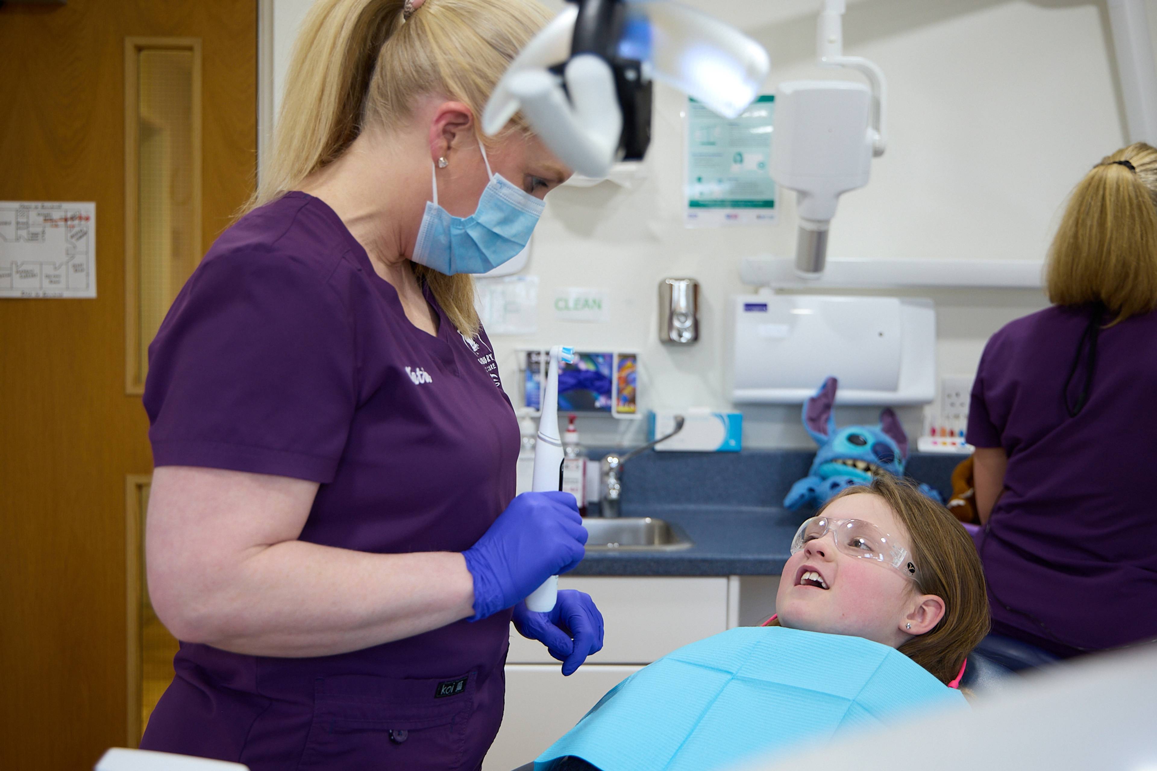 A hygienist demonstrates proper bushing technique using a toothbrush