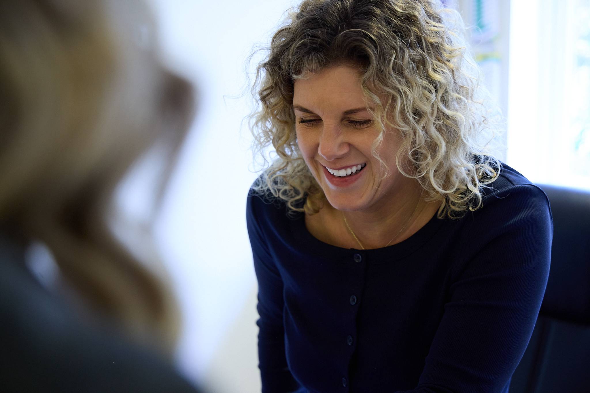 Receptionist smiling whilst talking to patient at front desk