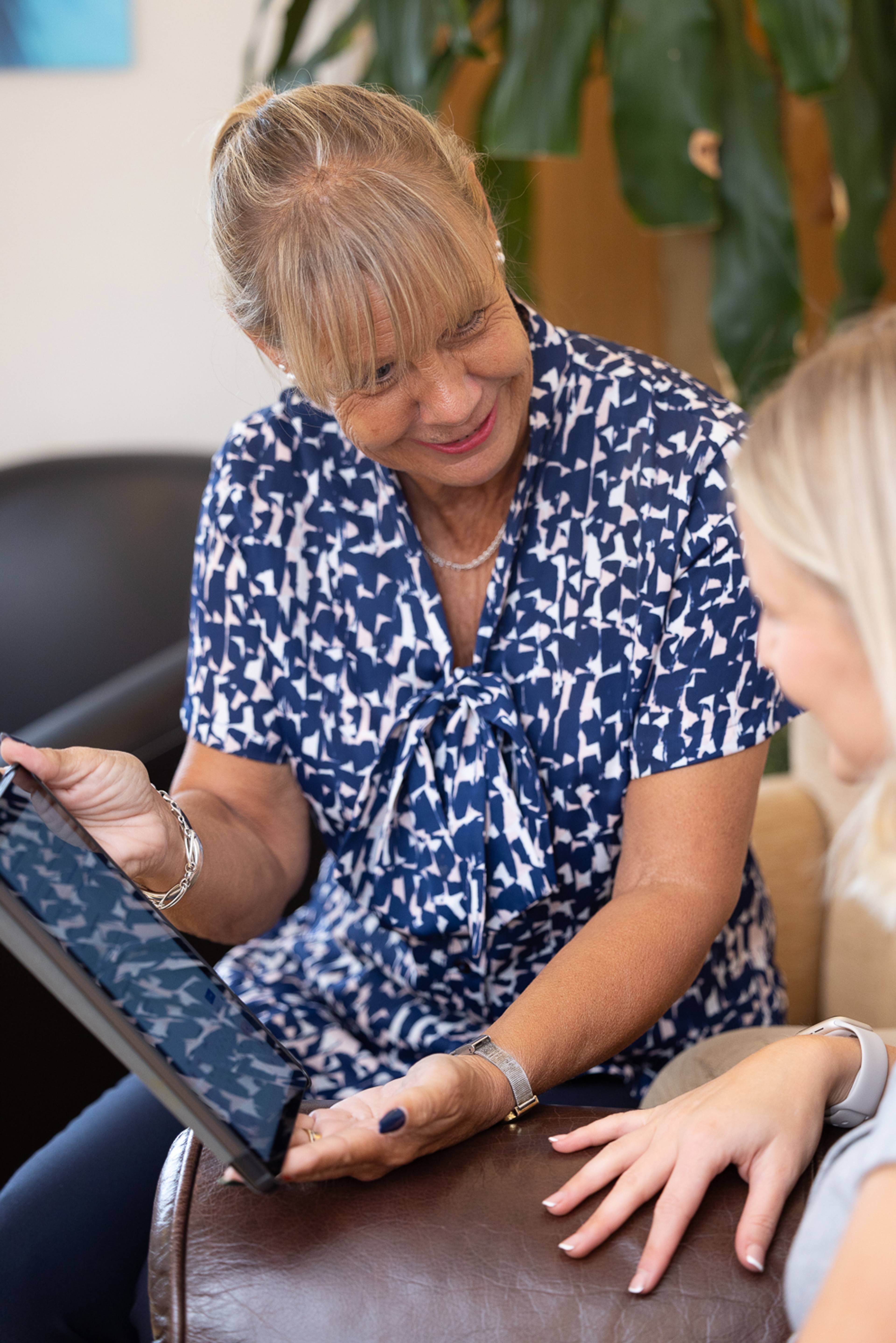 A receptionist shows pricing information to a patient