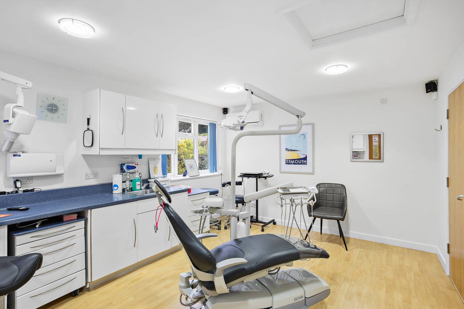 A bright treatment room with a chair and dental supplies on display