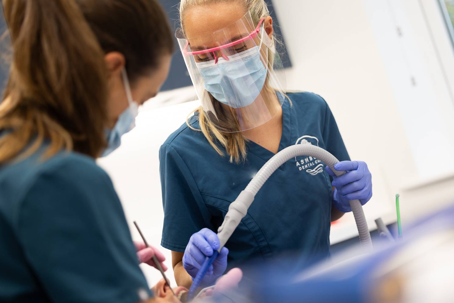 dentist and dental nurse working on a patients teeth during a composite bonding procedure