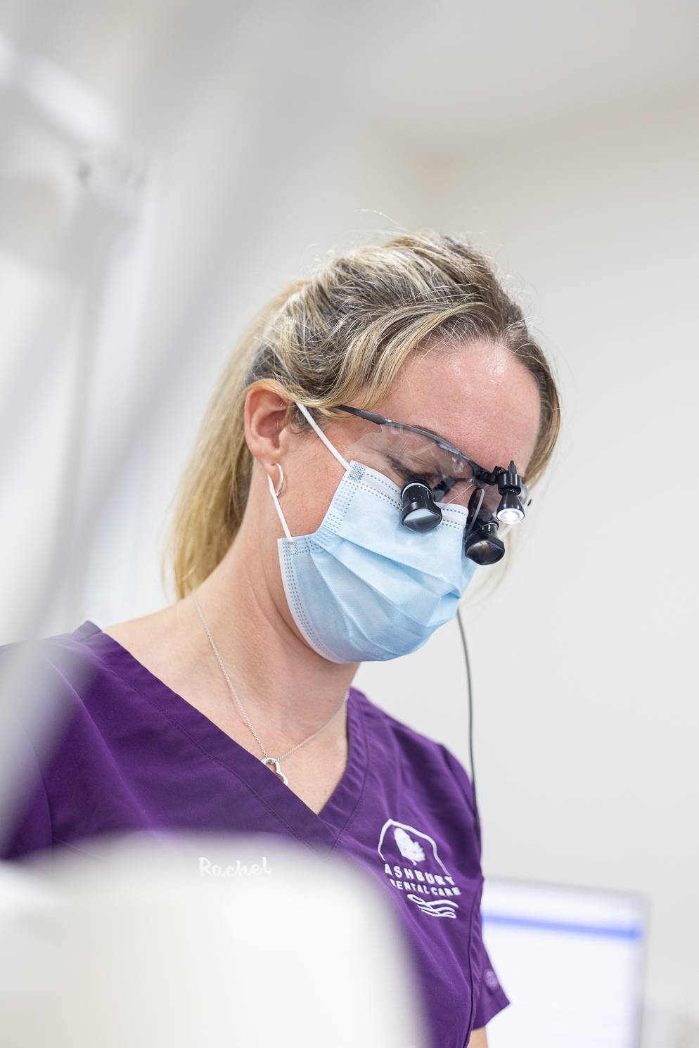 A dentist looking at a patient through loupes