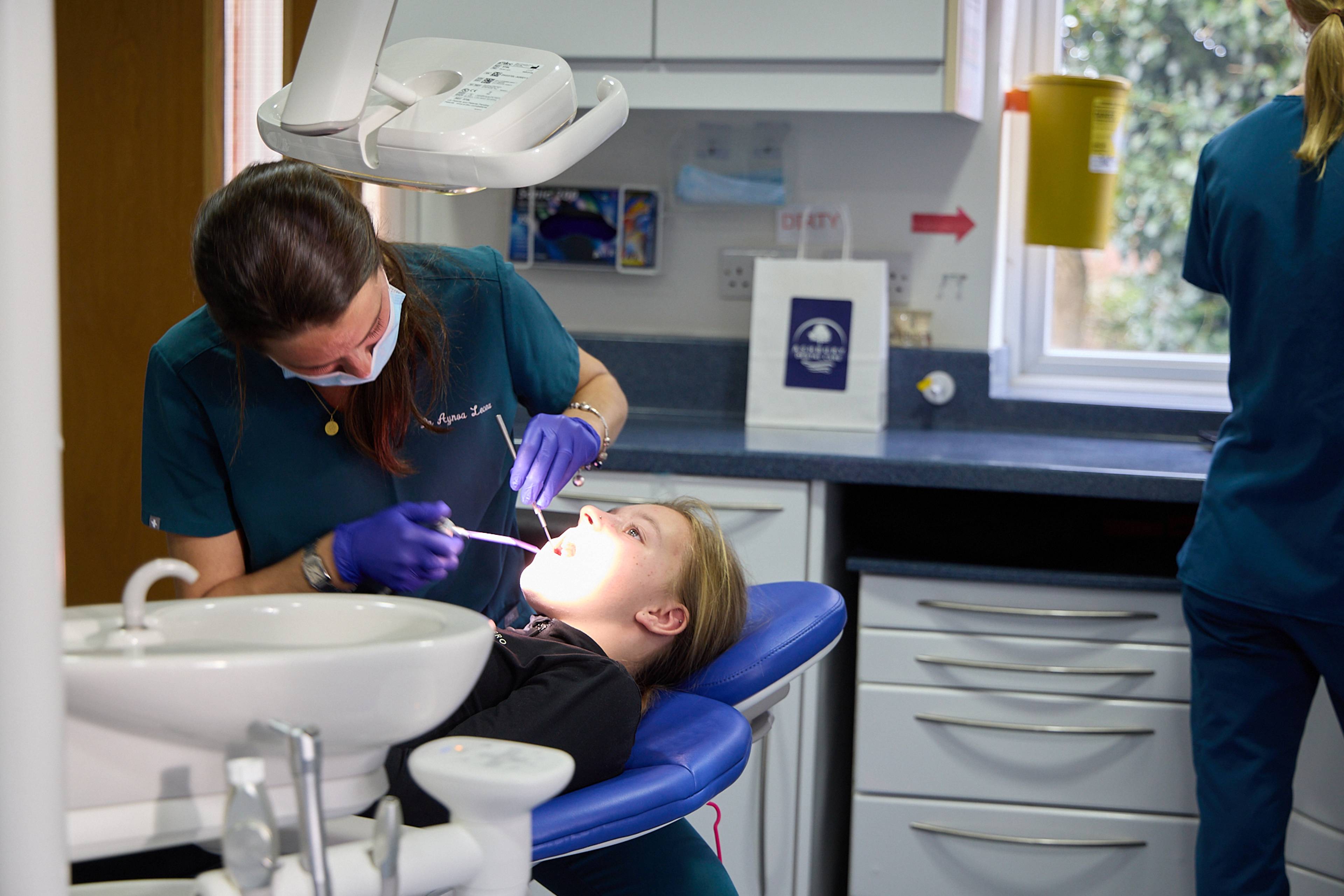 A dentist at Ashbury Dental Care treatment child in the dental chair