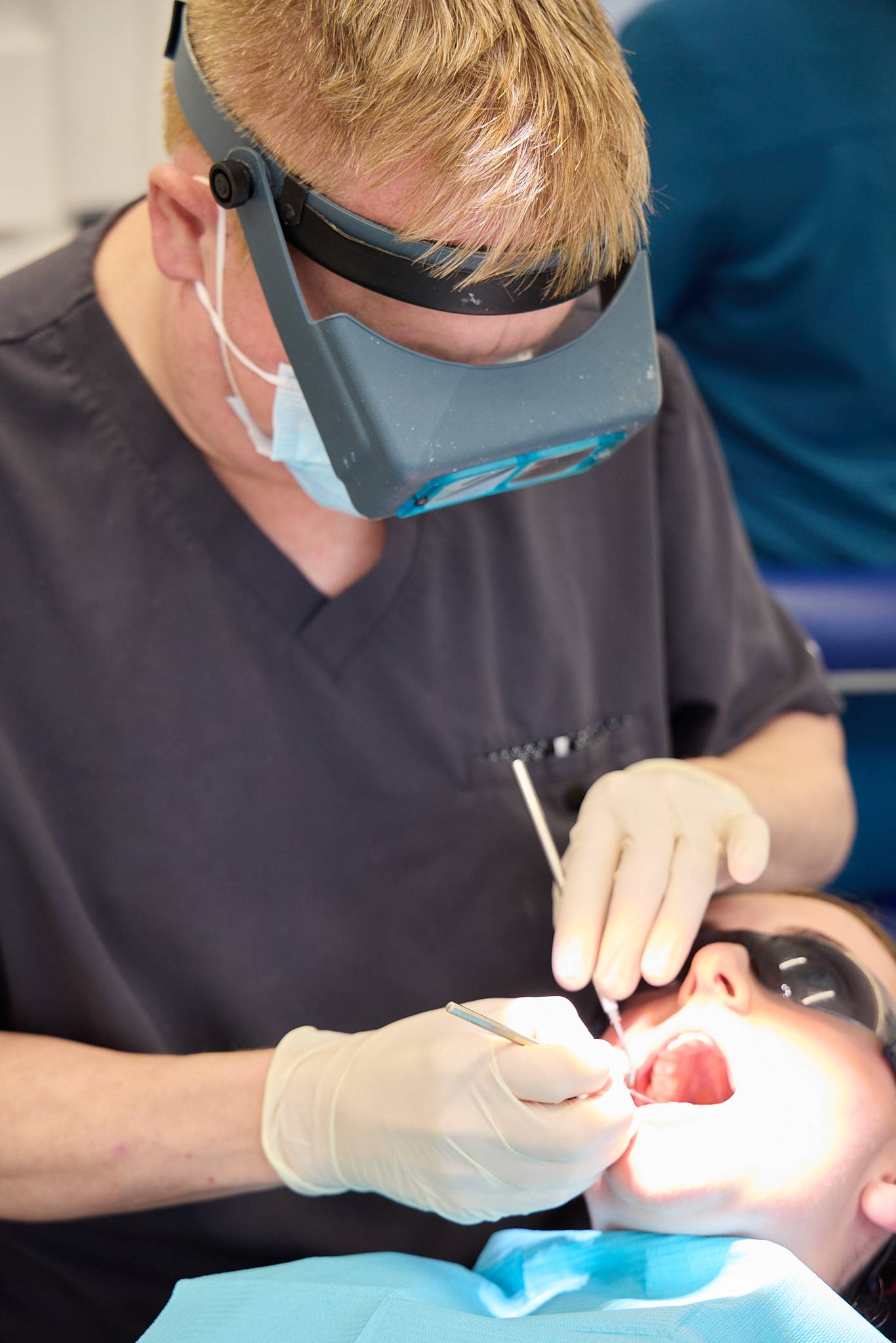 Dentist at Ashbury Dental Care working on patient using some dental tools