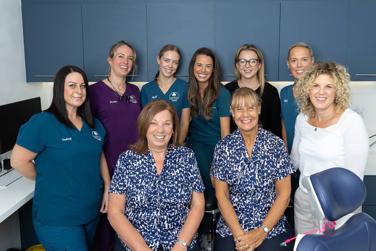 The team at Ashbury Dental Practice all together in a treatment room smiling