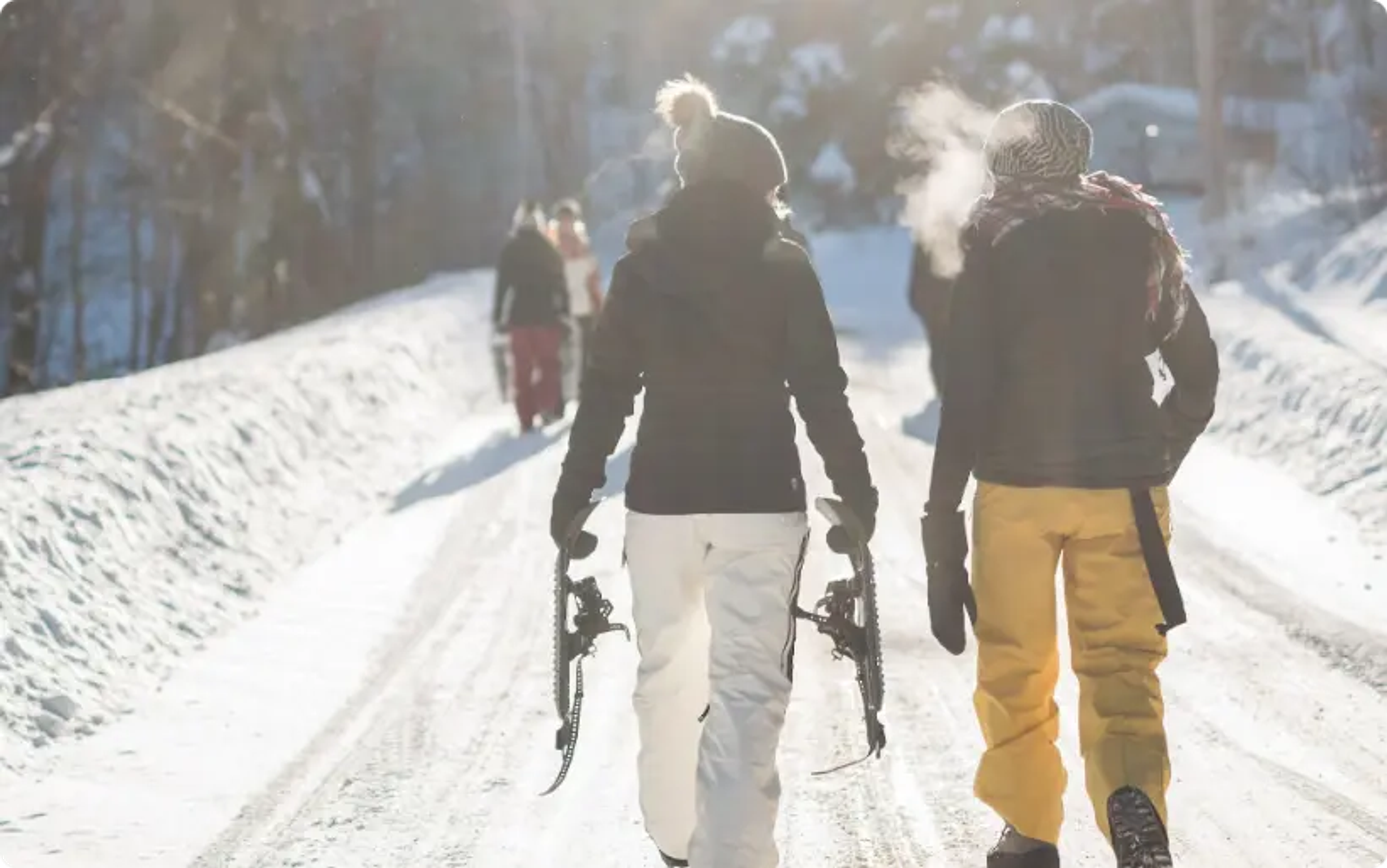 Person, die Schneeski hält, während sie tagsüber auf einem verschneiten Berg geht