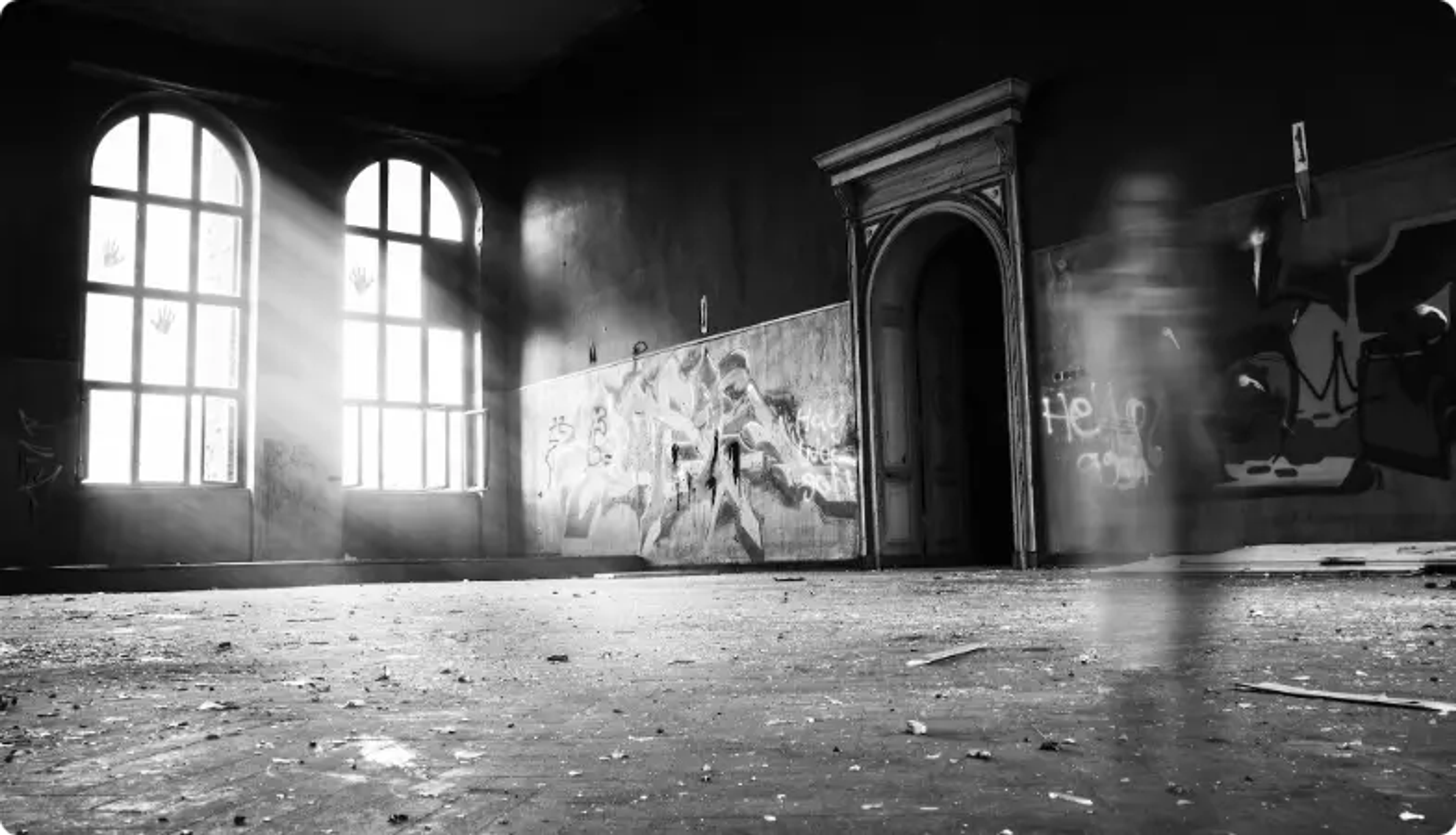 Verlassener Raum mit gewölbten Fenstern, Graffiti-Wand und hereinströmendem Sonnenlicht