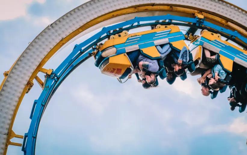 Pasajeros de montaña rusa al revés en una pista azul y amarilla