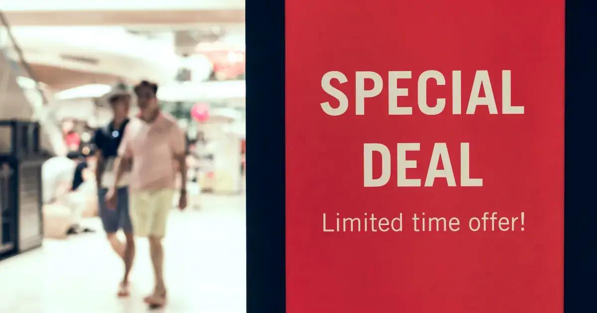 שלט מבצע מיוחד אדום עם קונים מטושטשים בסביבה קמעונאית